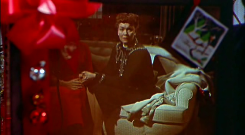 Jane Wyman's character gazes into a brand-new television. She is boxed-in and distanced from the world around her. 